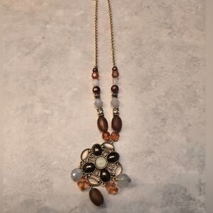 Beautiful gold necklace with brown and off-white beads.